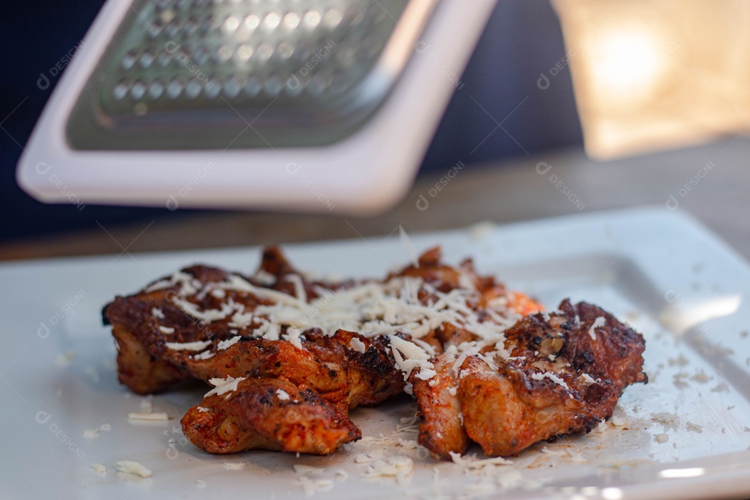 Carne assada com queijo ralado sobre uma prato branco churrasco