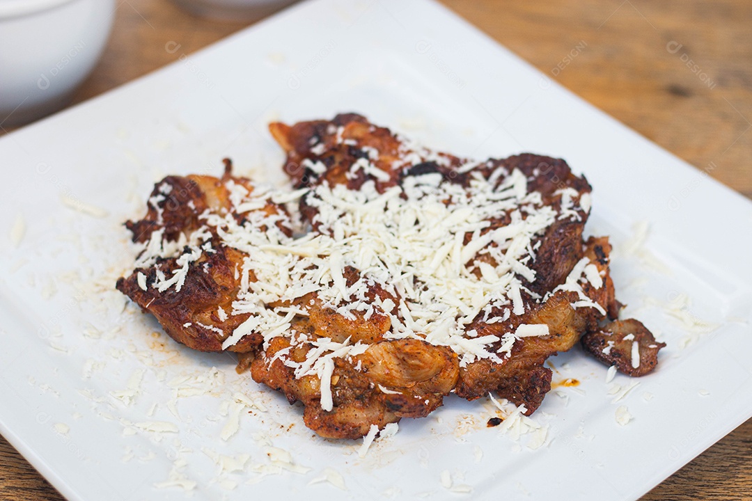 Carne assada com queijo ralado sobre uma prato branco churrasco