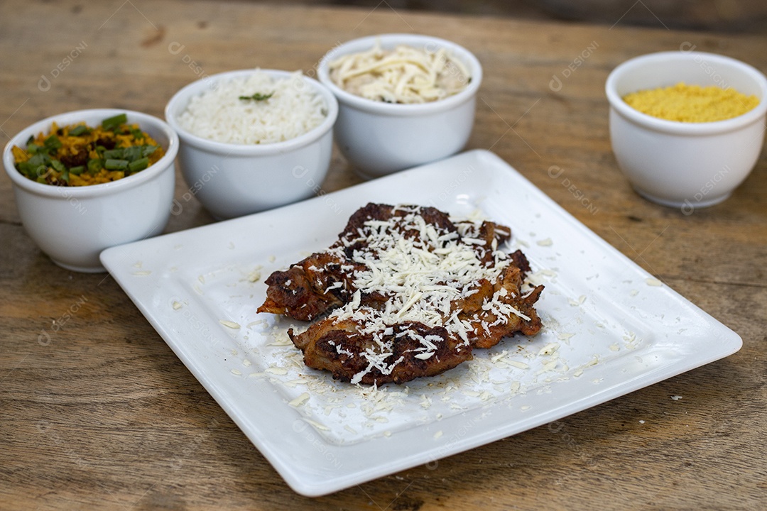 Carne assada suculenta com queijo servida em um prato branco com acompanhamentos