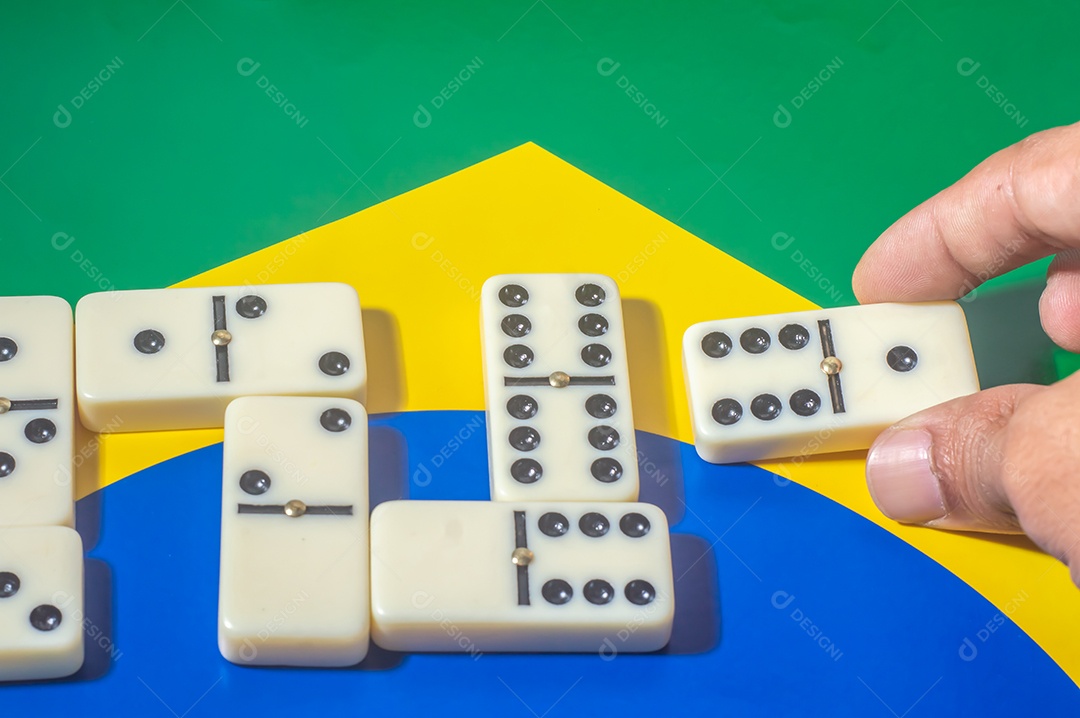 Jogo de dominó sobre uma bandeira verde amarela e azul, colo brasileiro