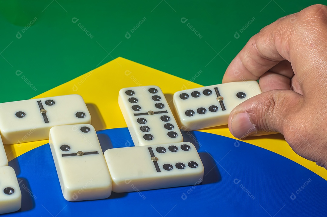 Jogo de dominó sobre uma bandeira verde amarela e azul, colo brasileiro