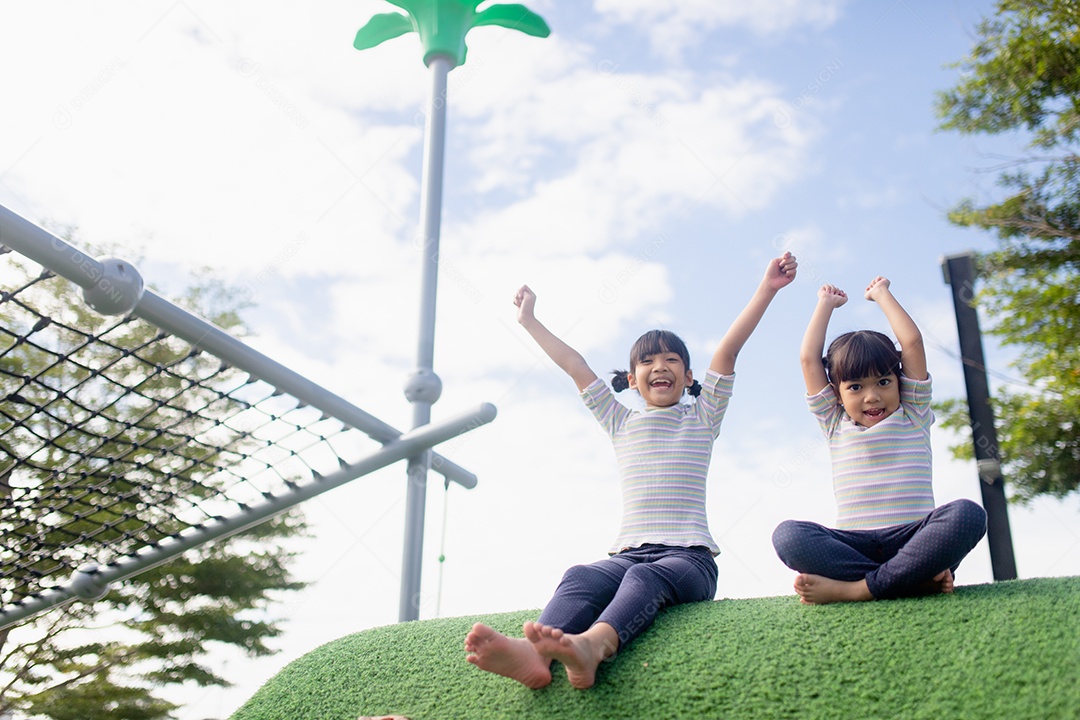 Criança brincando no playground ao ar livre. As crianças brincam na escola ou no jardim de infância. Garoto ativo no escorregador colorido e balanço