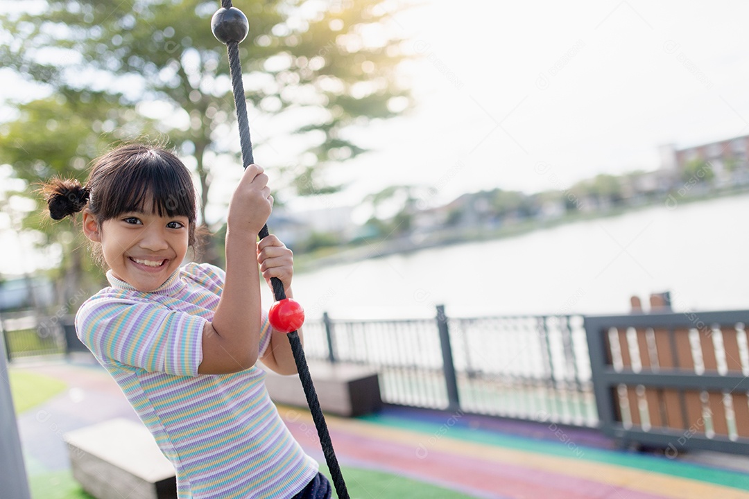 Garota garoto fazendo exercícios de escalada na corda bamba no jardim de infância ou escola primária. Conceito de esporte e fitness infantil.