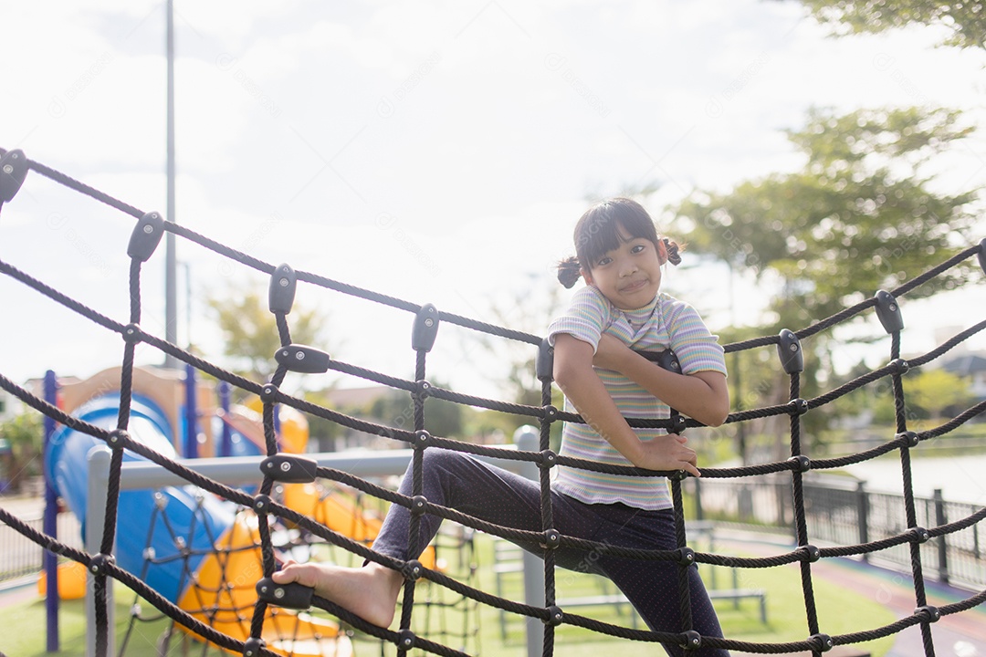 Garota garoto fazendo exercícios de escalada na corda bamba no jardim de infância ou escola primária. Conceito de esporte e fitness infantil.