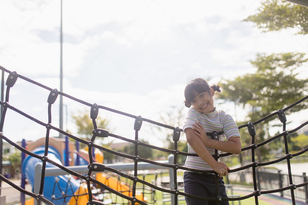 Garota garoto fazendo exercícios de escalada na corda bamba no jardim de infância ou escola primária. Conceito de esporte e fitness infantil.