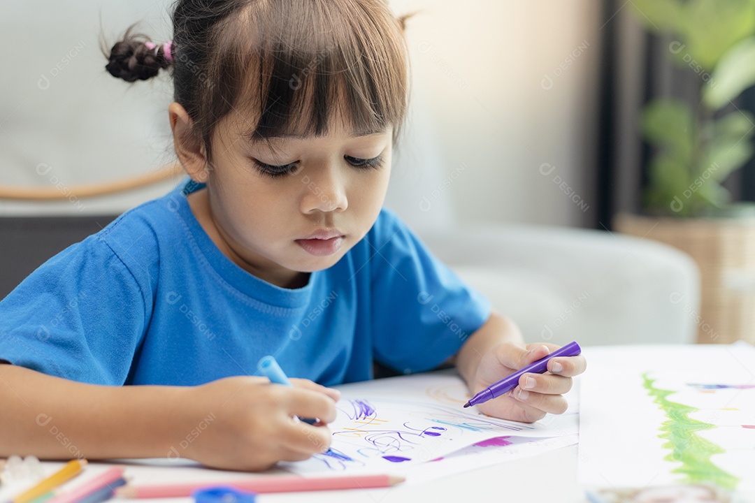 Menina bonitinha pinta e conserta com lápis de cor e tesoura