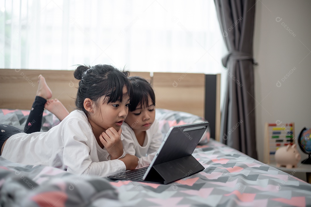Irmãos juntos na cama usando tablet