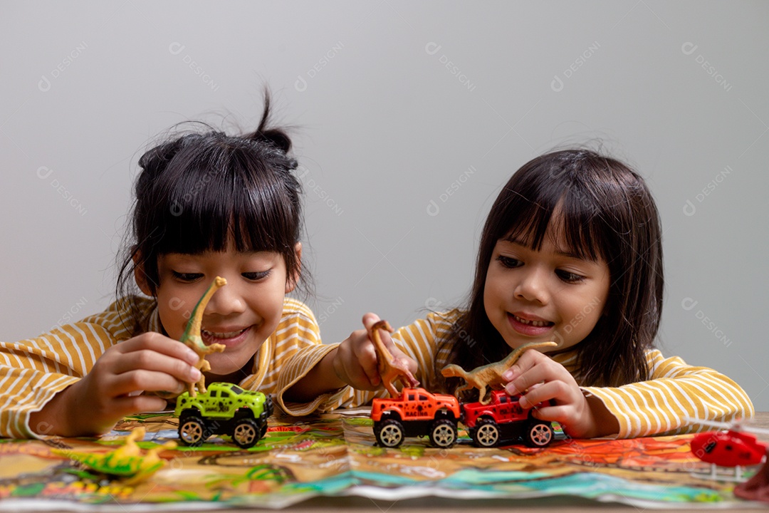 Irmãos das crianças brincam com brinquedos na mesa.