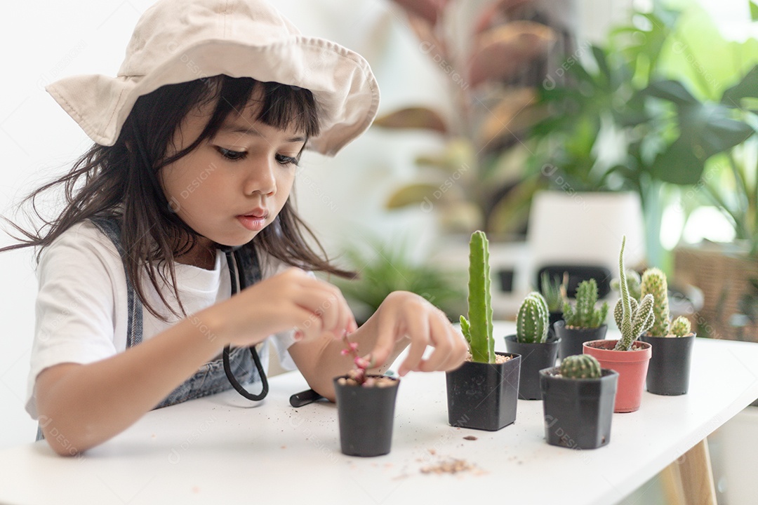 Kid toca suavemente o novo caule do cacto que ele cultiva com cuidado, educação da natureza, Montessori e conceitos de habilidades de observação.