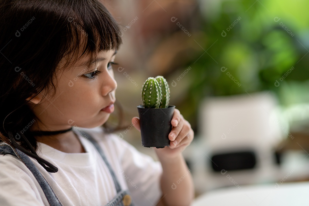 Kid toca suavemente o novo caule do cacto que ele cultiva com cuidado, educação da natureza, Montessori e conceitos de habilidades de observação.