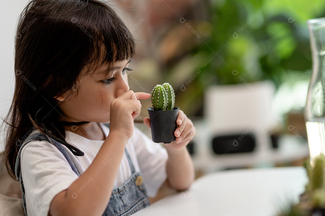 Kid toca suavemente o novo caule do cacto que ele cultiva com cuidado, educação da natureza, Montessori e conceitos de habilidades de observação.