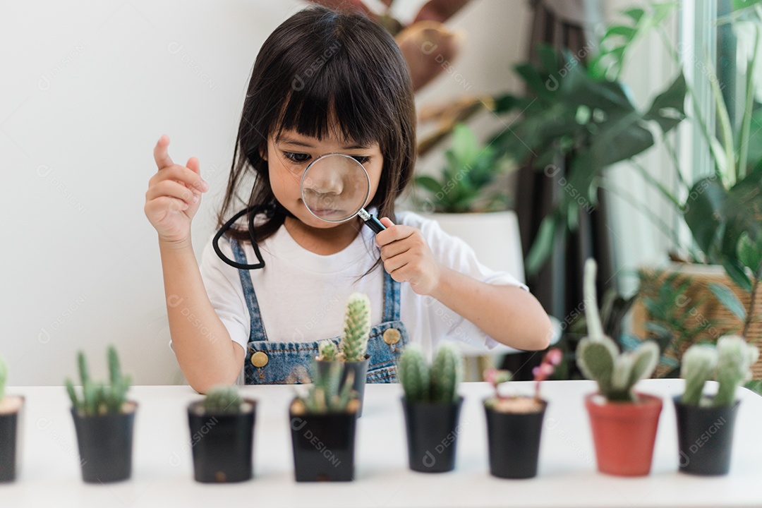 Kid toca suavemente o novo caule do cacto que ele cultiva com cuidado, educação da natureza, Montessori e conceitos de habilidades de observação.