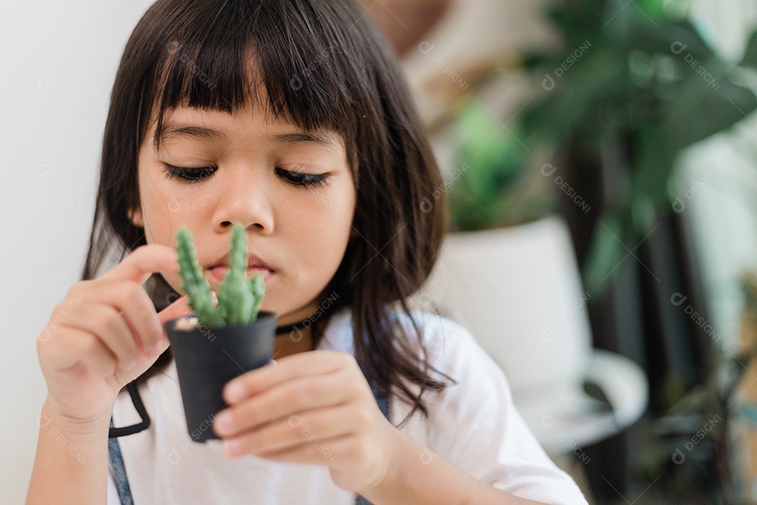 Kid toca suavemente o novo caule do cacto que ele cultiva com cuidado, educação da natureza, Montessori e conceitos de habilidades de observação.