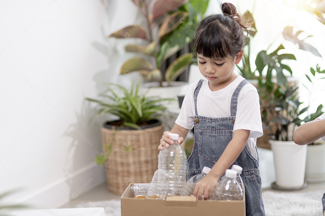 Menina segurando garrafas plásticas para reciclagem