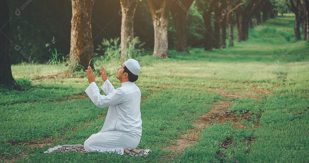 Homem muçulmano religioso tradicional kandura orando ao ar livre em raios de sol de ambiente de natureza tranquila.