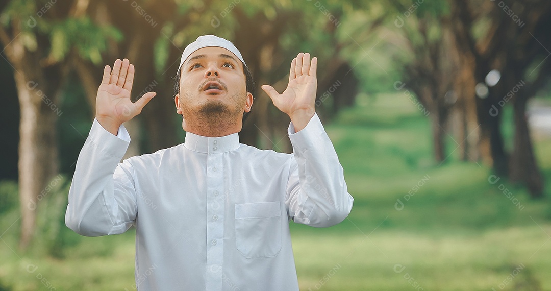 Traditional kandura religious muslim man praying outdoor in tranquil nature environment sun rays.
