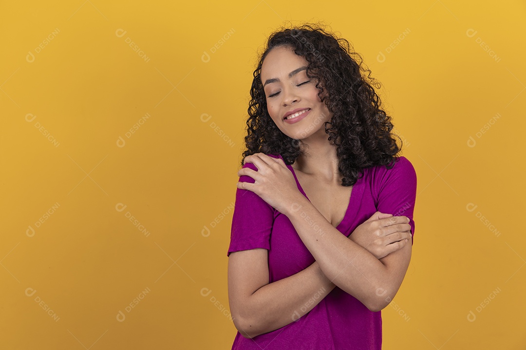 Mulher jovem cabelo cacheado sobre fundo amarelo