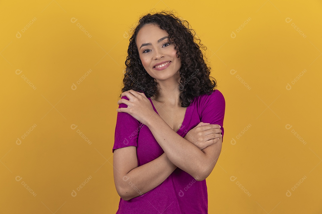 Mulher jovem cabelo cacheado sobre fundo amarelo