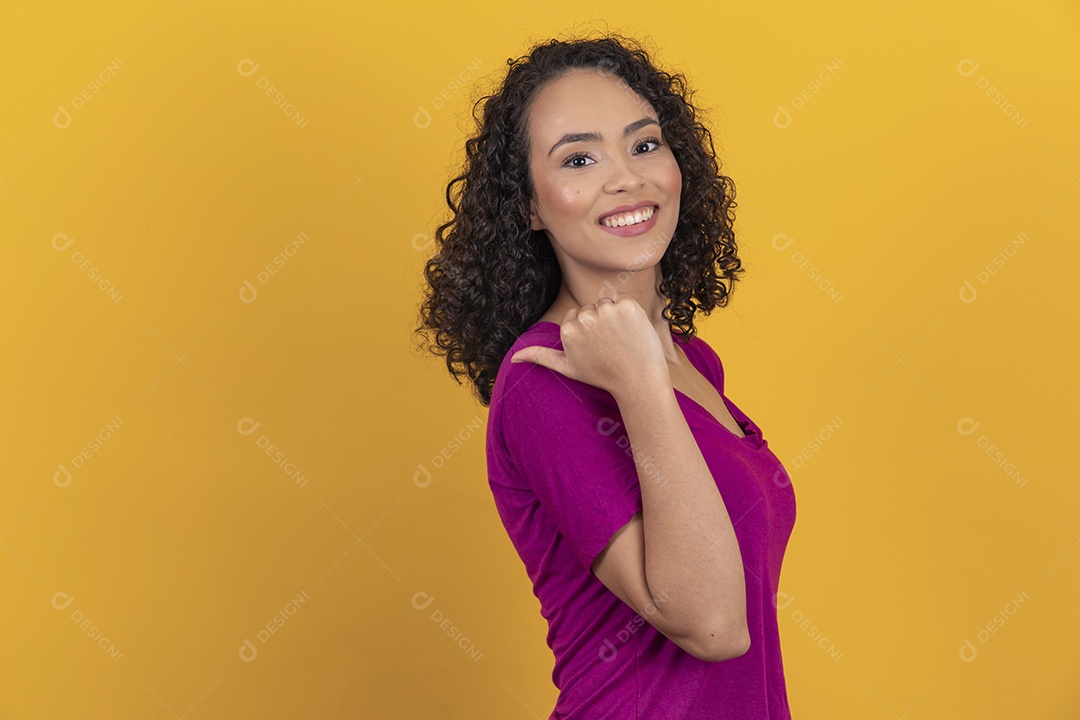 Mulher jovem cabelo cacheado sobre fundo amarelo