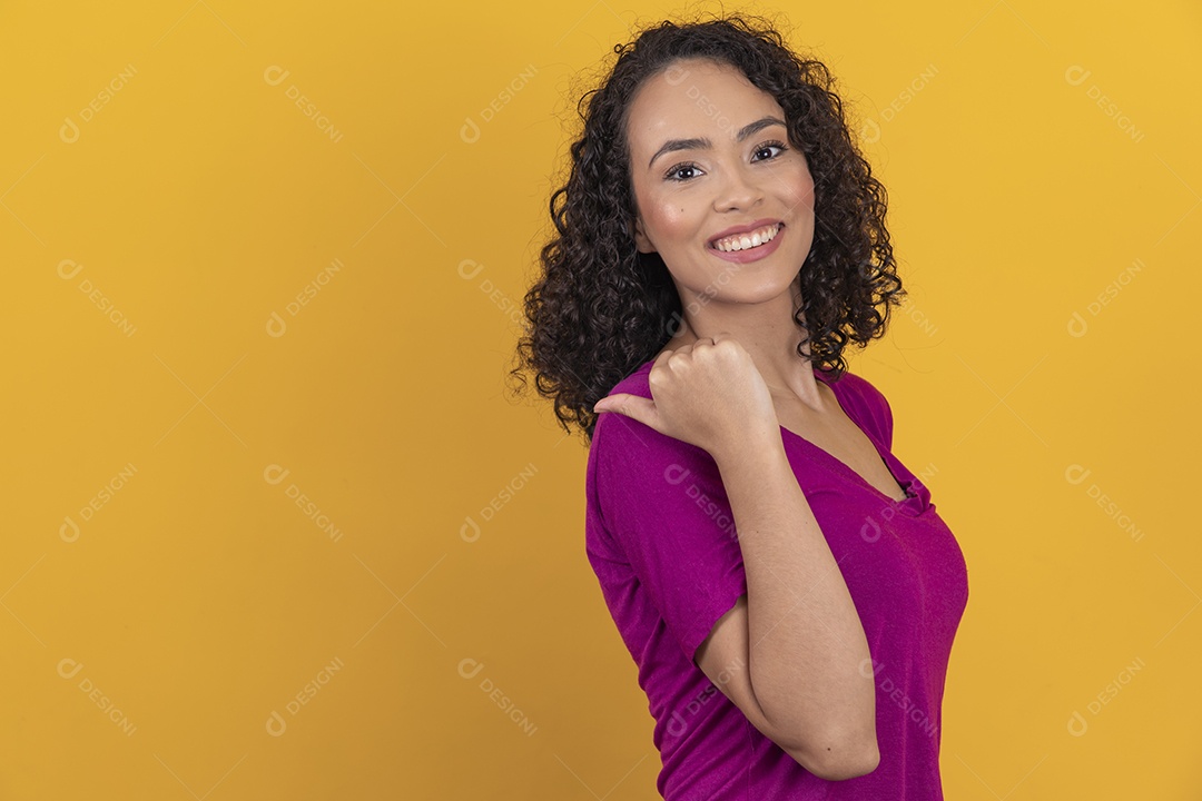Mulher jovem cabelo cacheado sobre fundo amarelo