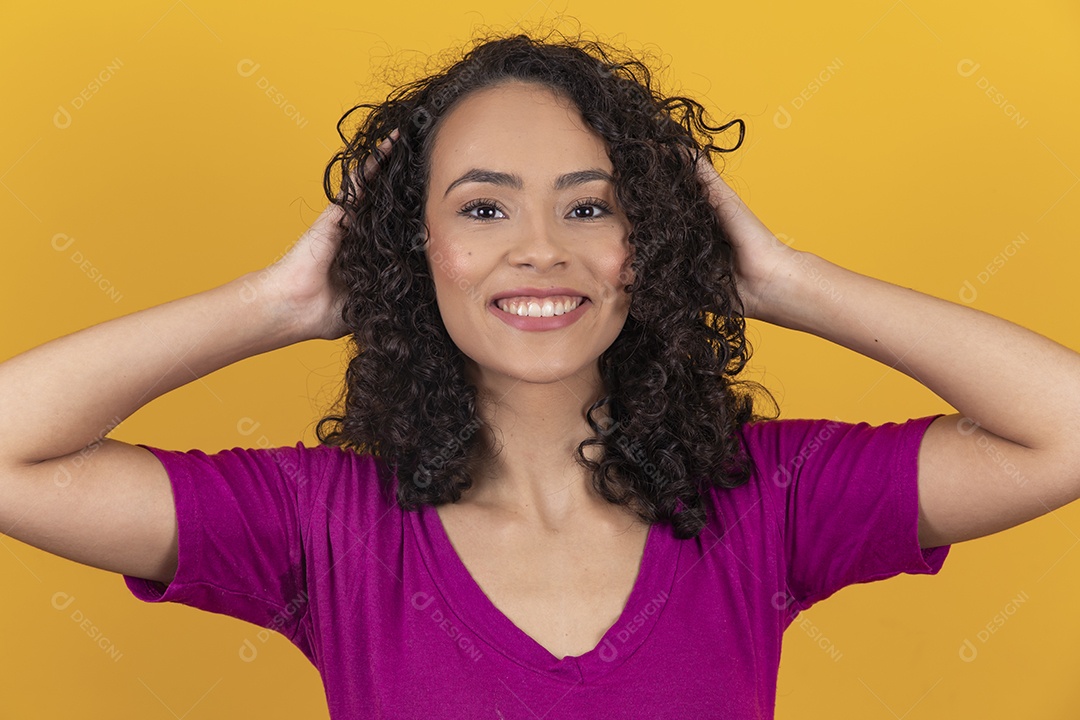 Mulher jovem cabelo cacheado sobre fundo amarelo
