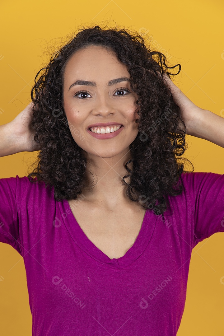 Mulher jovem cabelo cacheado sobre fundo amarelo