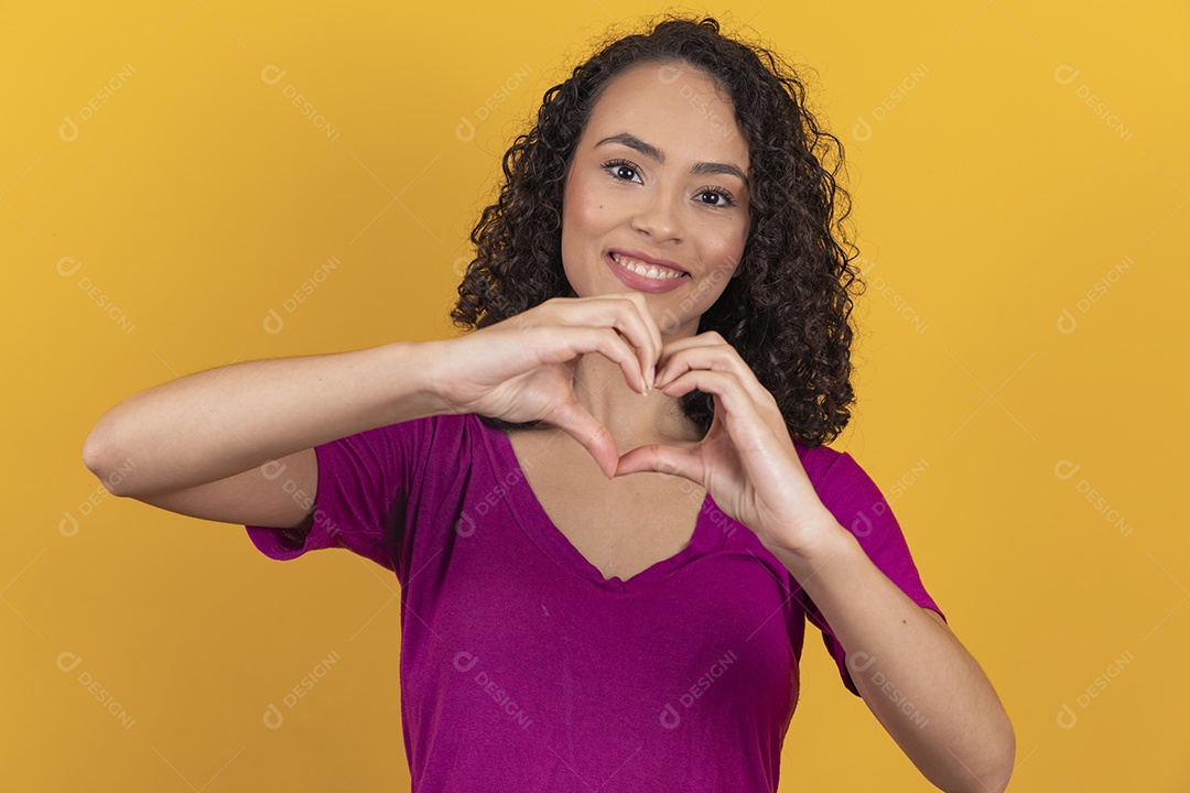 Mulher jovem cabelo cacheado sobre fundo amarelo