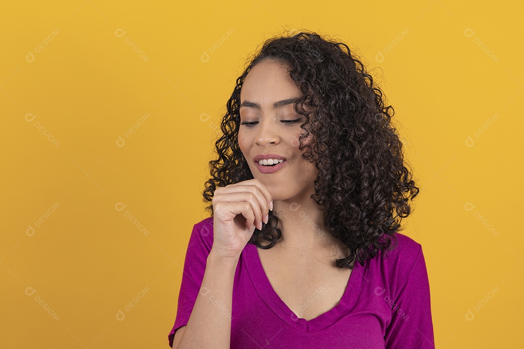 Mulher jovem cabelo cacheado sobre fundo amarelo