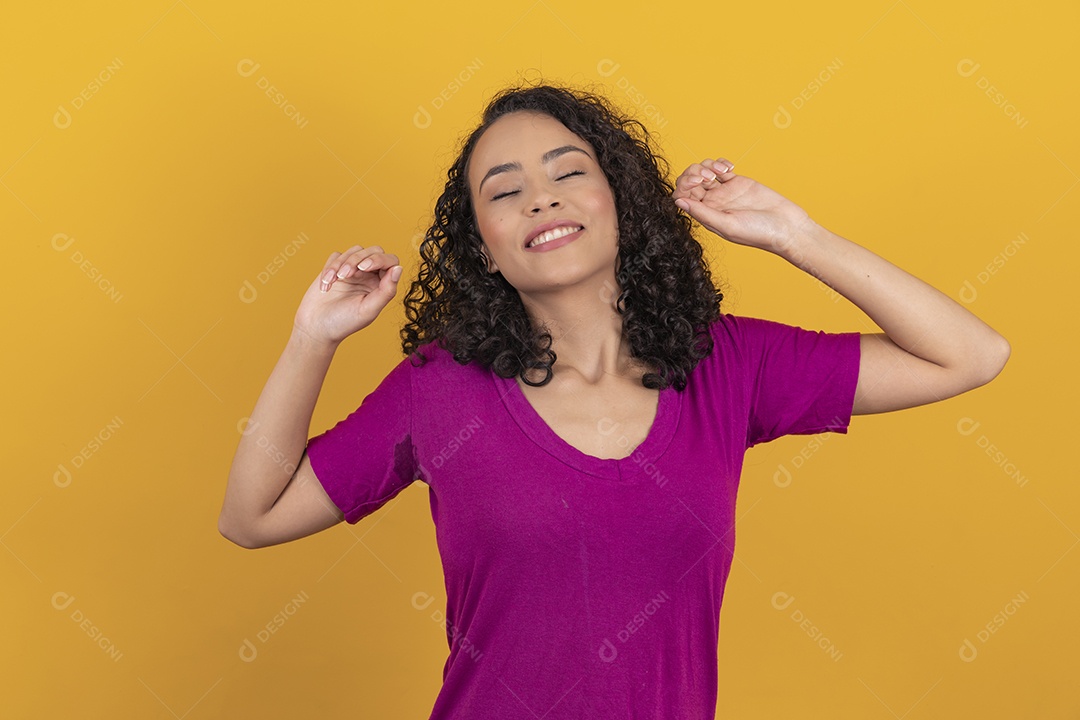 Mulher jovem cabelo cacheado sobre fundo amarelo