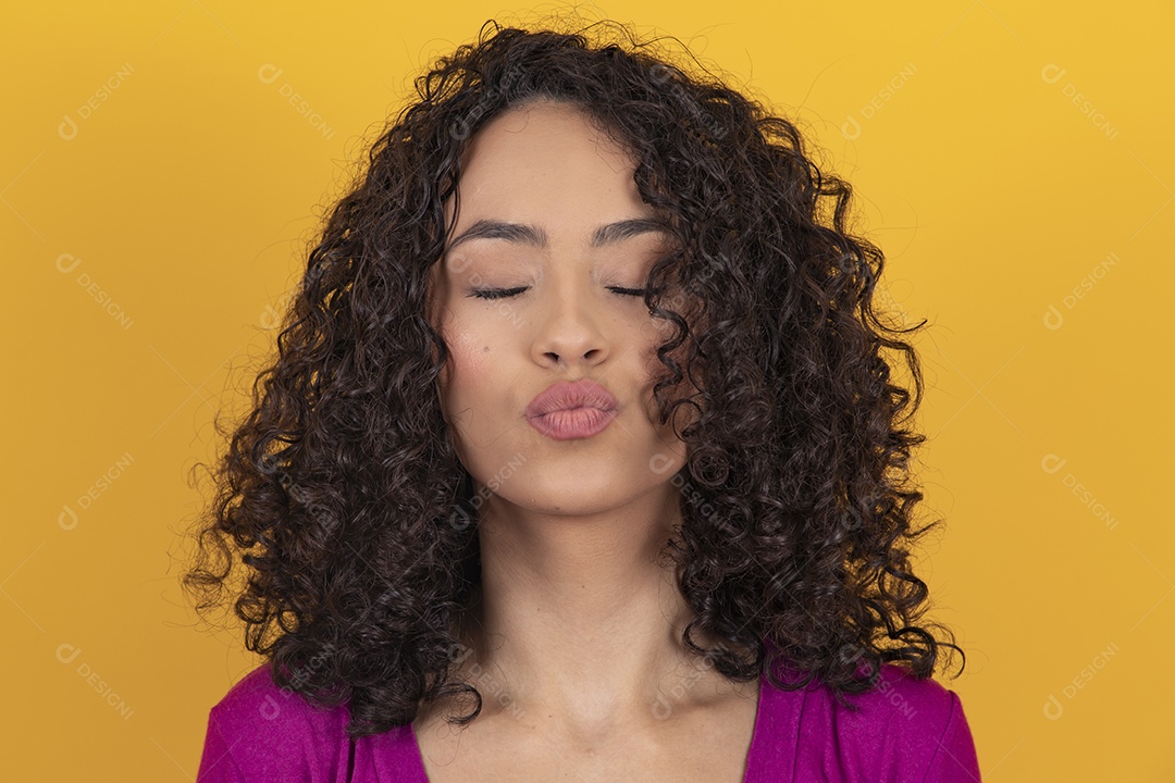 Mulher jovem cabelo cacheado sobre fundo amarelo