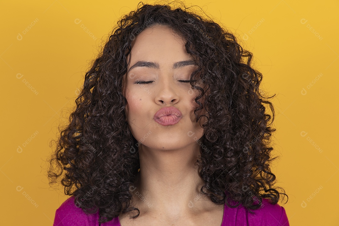 Mulher jovem cabelo cacheado sobre fundo amarelo