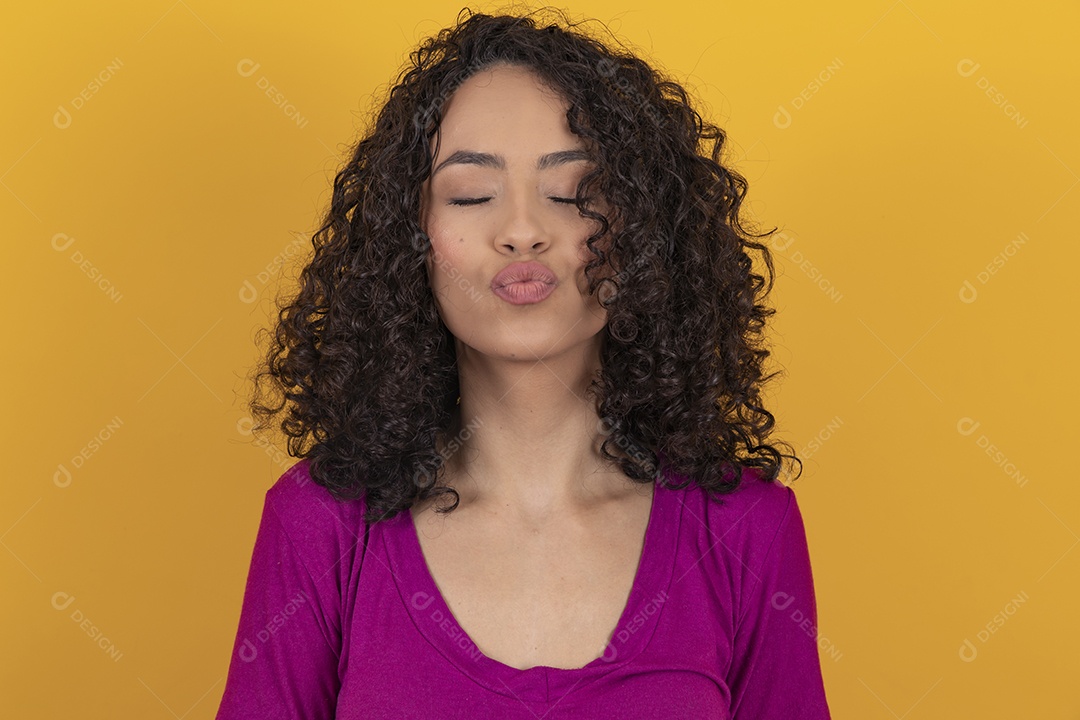 Mulher jovem cabelo cacheado sobre fundo amarelo