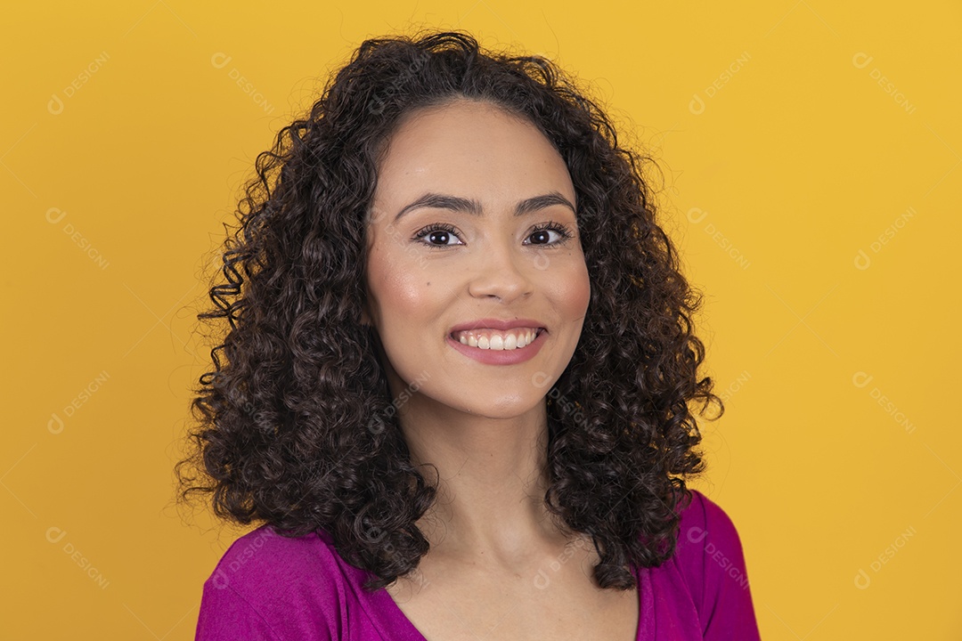Mulher jovem cabelo cacheado sobre fundo amarelo