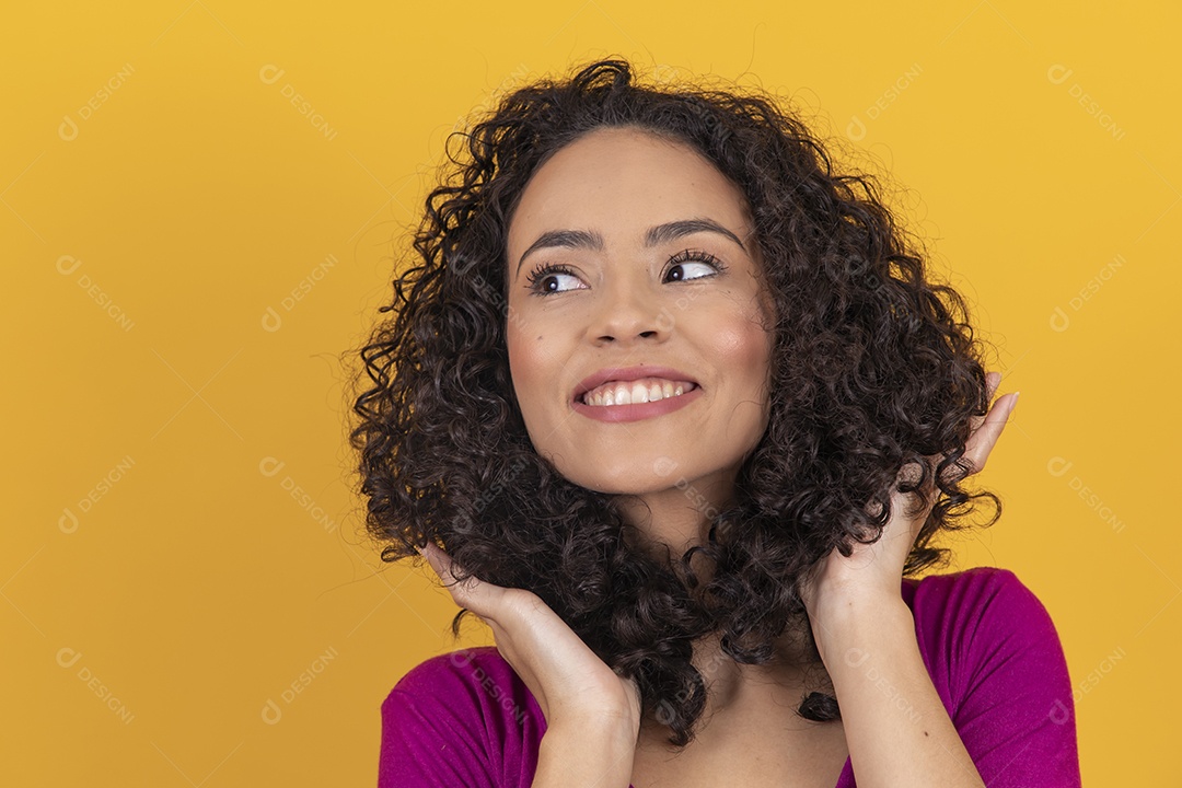 Mulher jovem cabelo cacheado sobre fundo amarelo