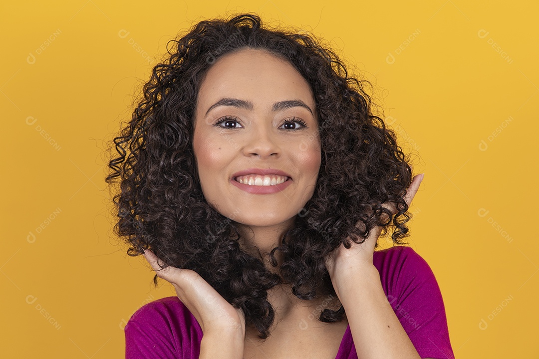 Mulher jovem cabelo cacheado sobre fundo amarelo