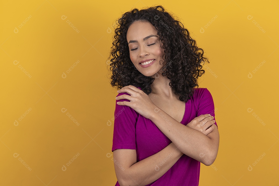 Mulher jovem cabelo cacheado sobre fundo amarelo