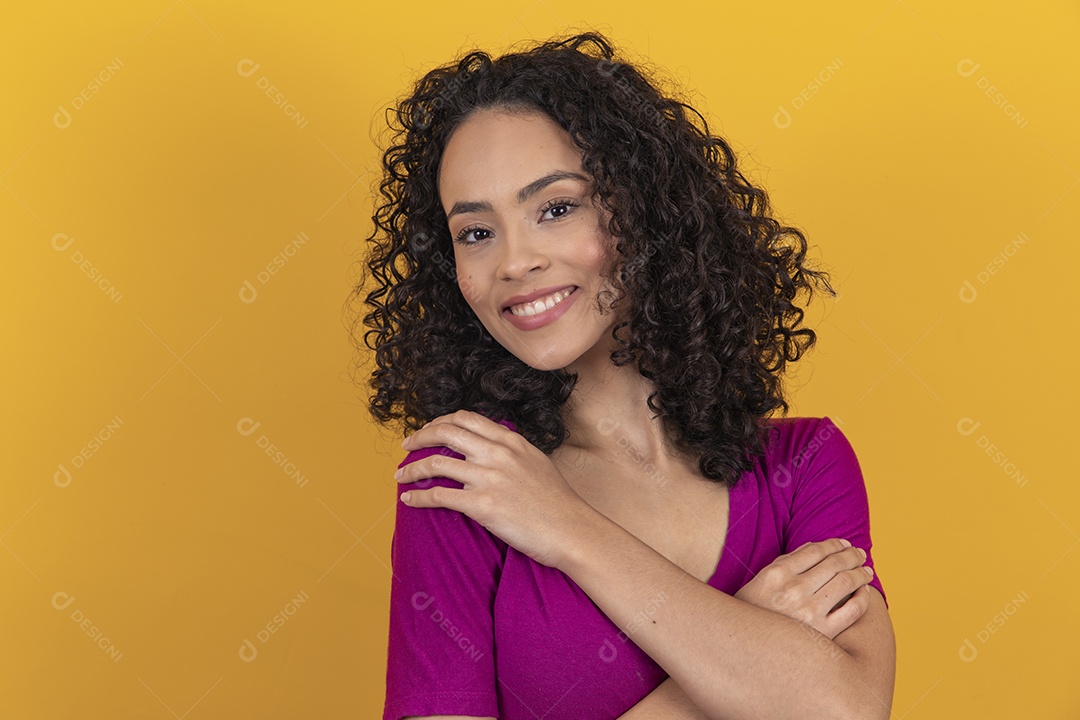 Mulher jovem cabelo cacheado sobre fundo amarelo