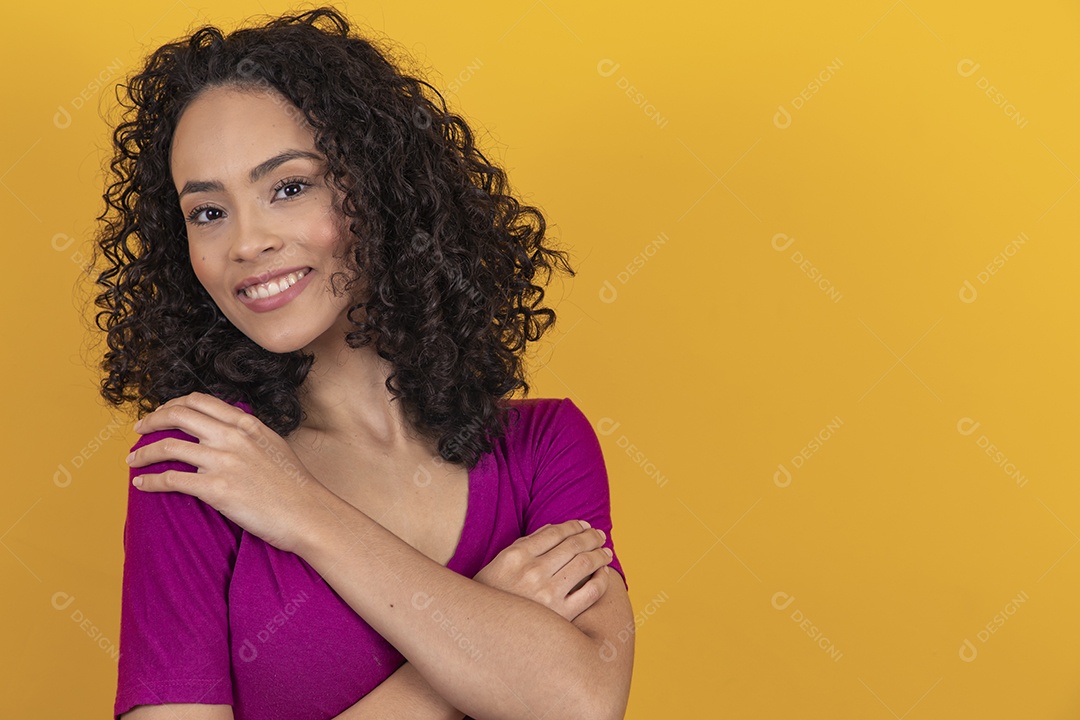 Mulher jovem cabelo cacheado sobre fundo amarelo