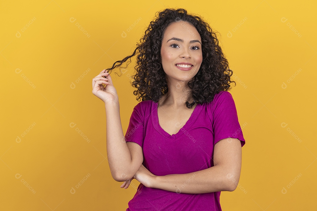 Mulher jovem cabelo cacheado sobre fundo amarelo