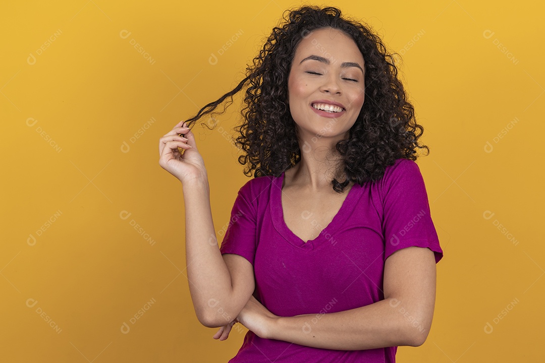 Mulher jovem cabelo cacheado sobre fundo amarelo