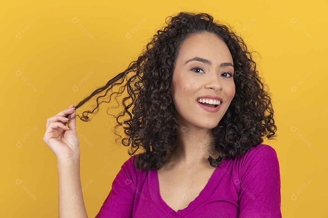 Mulher jovem cabelo cacheado sobre fundo amarelo