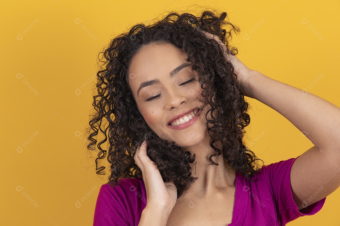Mulher jovem cabelo cacheado sobre fundo amarelo