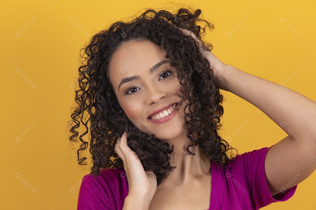 Mulher jovem cabelo cacheado sobre fundo amarelo