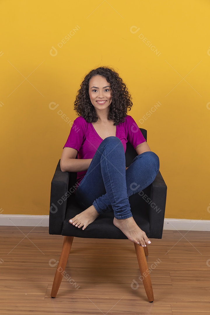 Mulher jovem cabelo cacheado sobre fundo amarelo