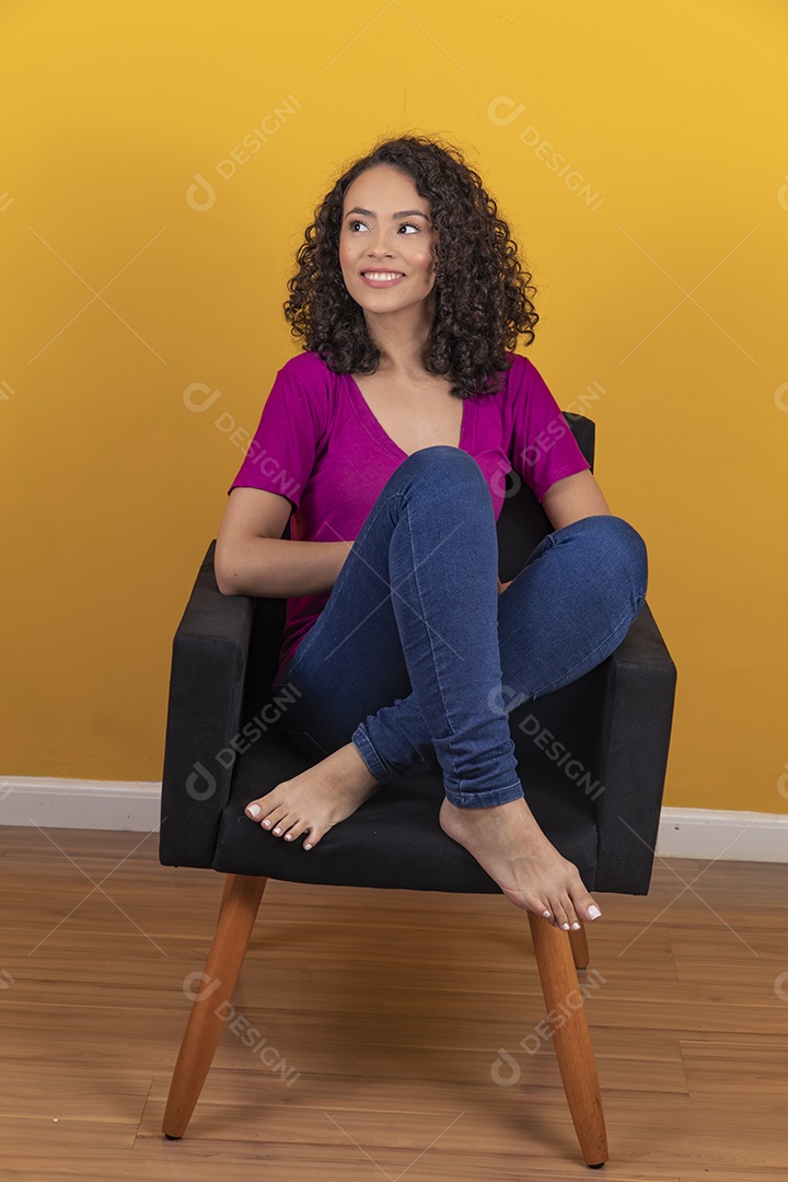 Mulher jovem cabelo cacheado sobre fundo amarelo