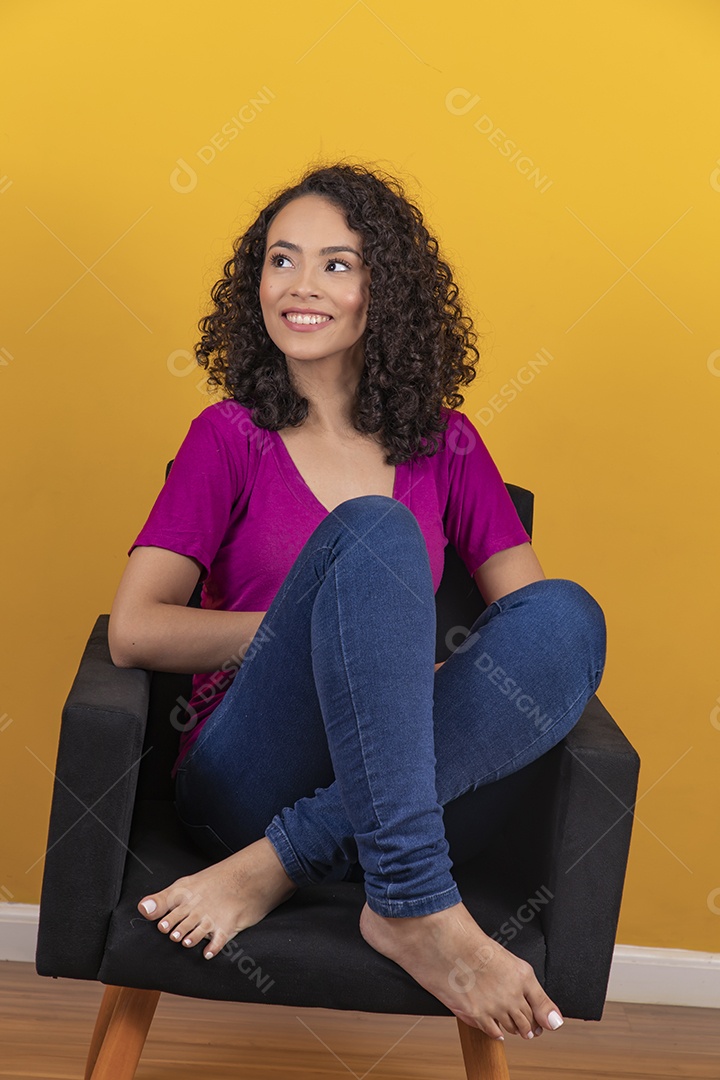 Mulher jovem cabelo cacheado sobre fundo amarelo