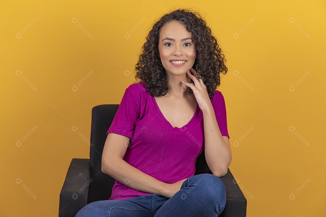 Mulher jovem cabelo cacheado sobre fundo amarelo