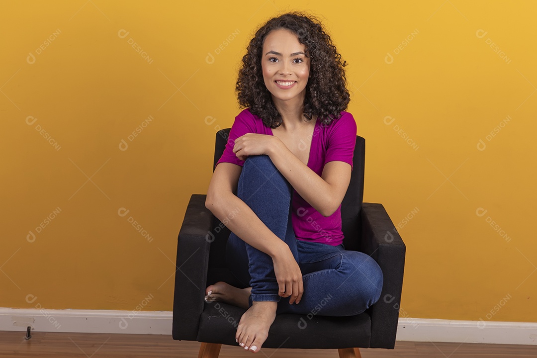Mulher jovem cabelo cacheado sobre fundo amarelo
