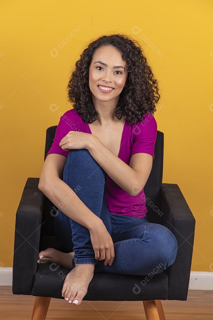 Mulher jovem cabelo cacheado sobre fundo amarelo