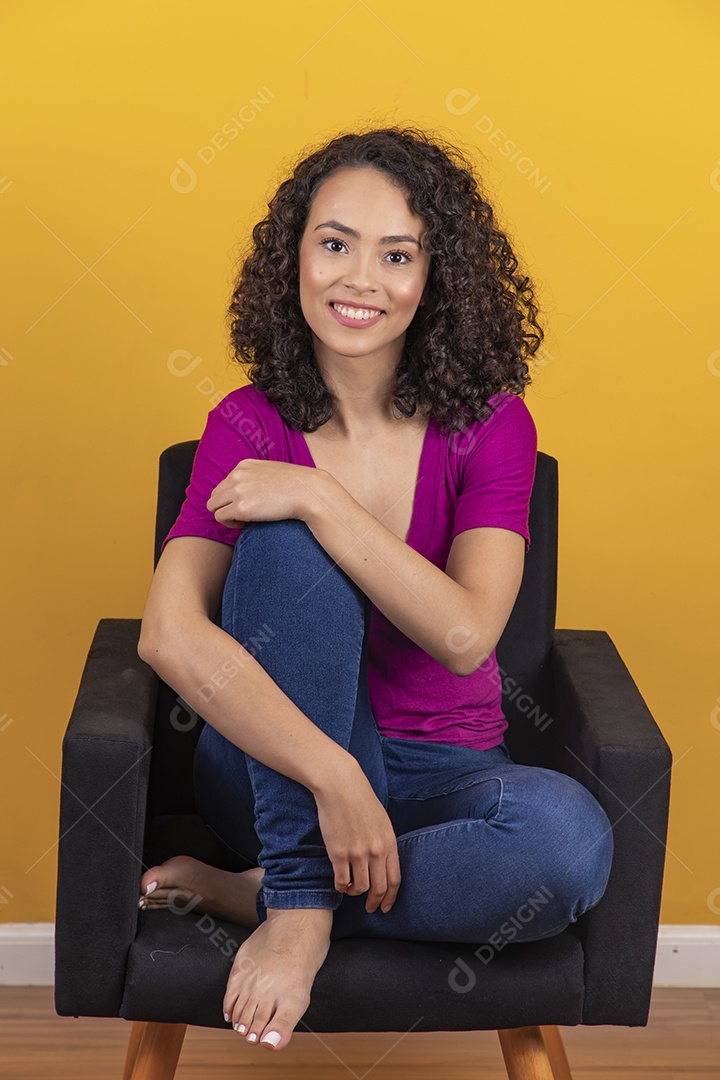 Mulher jovem cabelo cacheado sobre fundo amarelo